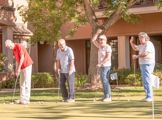 A group of seniors enjoying a game of golf outdoors.