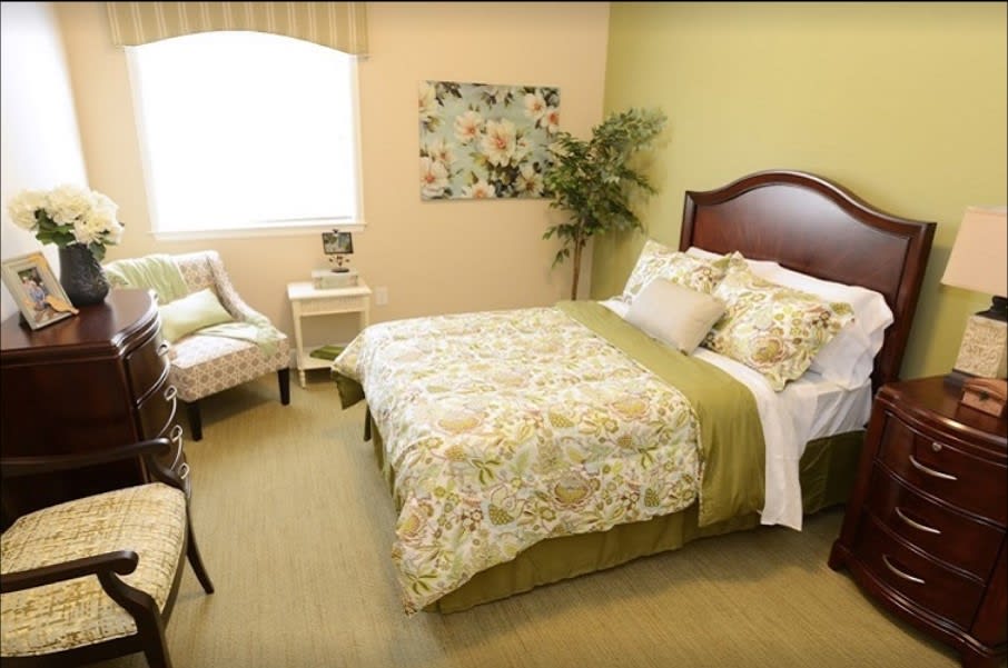 A cozy bedroom with a floral-patterned bedspread and elegant decor.