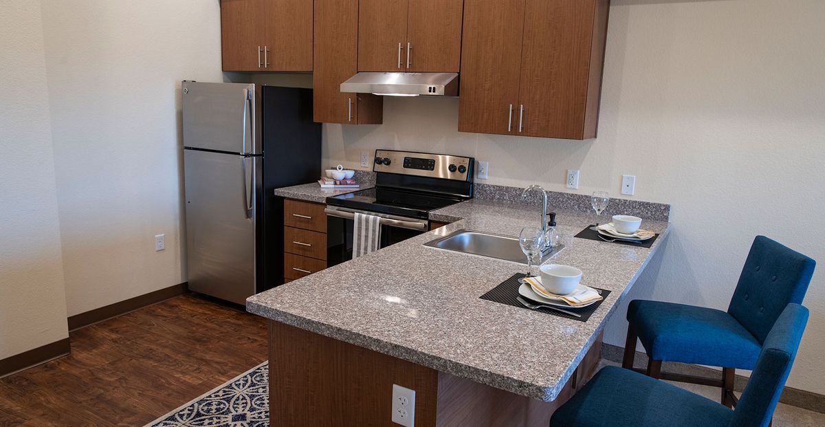 A modern kitchen with stainless steel appliances and a granite countertop.