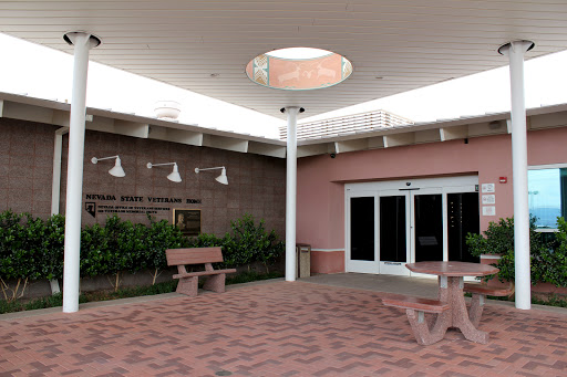 A modern courtyard featuring benches and a skylight, surrounded by landscaped greenery.