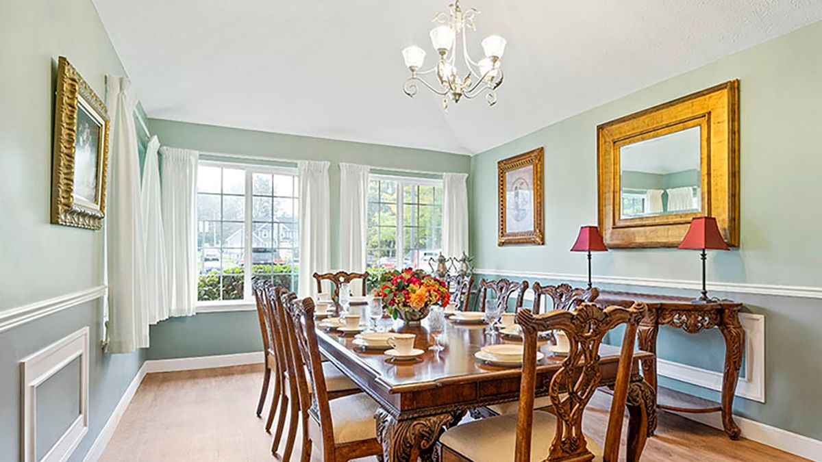 A well-decorated dining room with a large table, elegant chairs, and a chandelier.