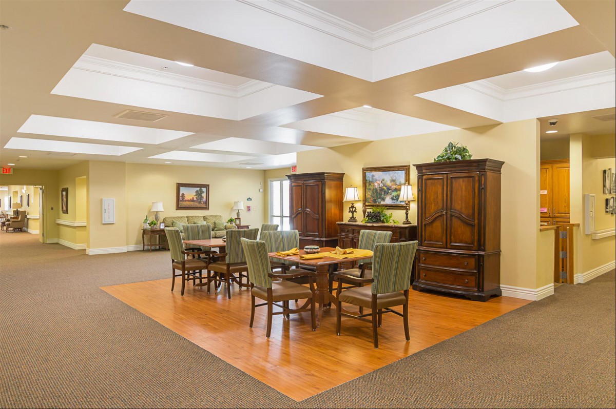 A well-lit dining area with wooden tables and chairs, featuring elegant decor and ample space.