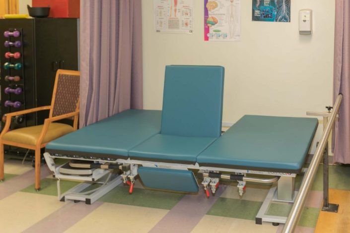 A physical therapy treatment table in a clinic setting.