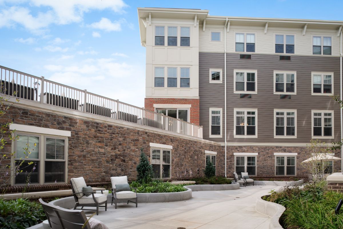Modern apartment building with outdoor seating and landscaped courtyard.