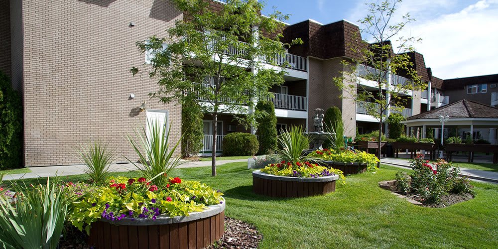 An apartment complex with well-maintained landscaping and flower beds.