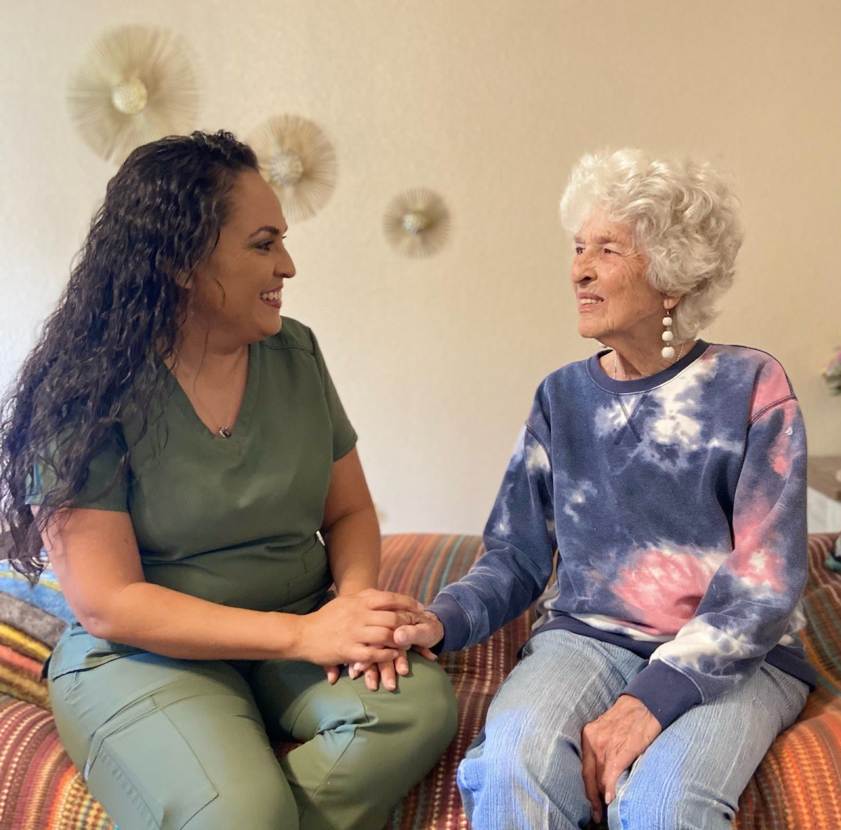 A caregiver and an elderly woman share a moment of companionship.