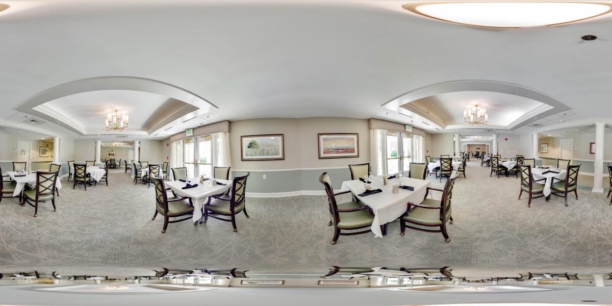 A well-decorated dining room with tables set with white tablecloths.