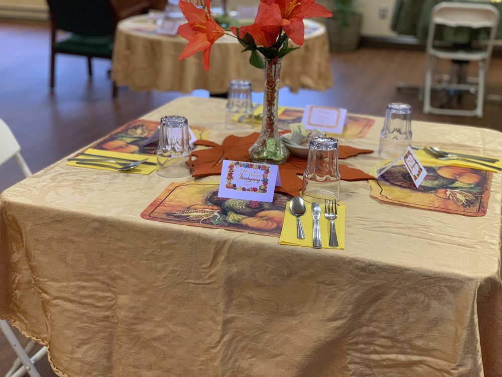 A beautifully set dining table adorned with a floral centerpiece and neatly arranged cutlery.