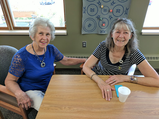 Two friends enjoying their time together at a table, sharing smiles.