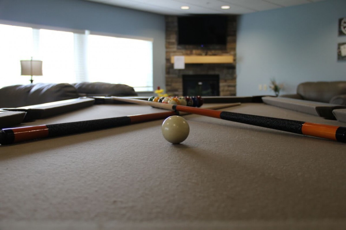 A pool table in a cozy game room setting.