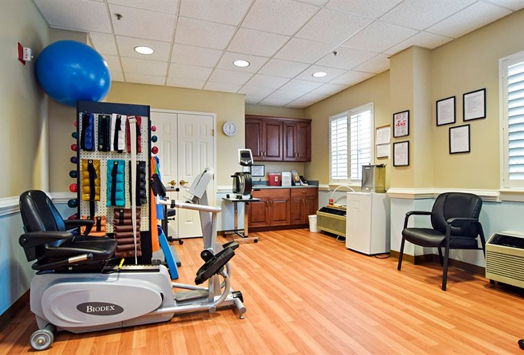A well-equipped physical therapy room with exercise machines and equipment.
