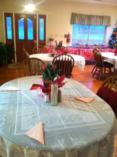 A cozy dining area decorated for the holiday season, featuring elegantly set tables and festive decor.