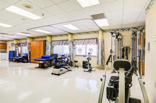 A well-equipped physical therapy room featuring various exercise machines and a bright, spacious environment.