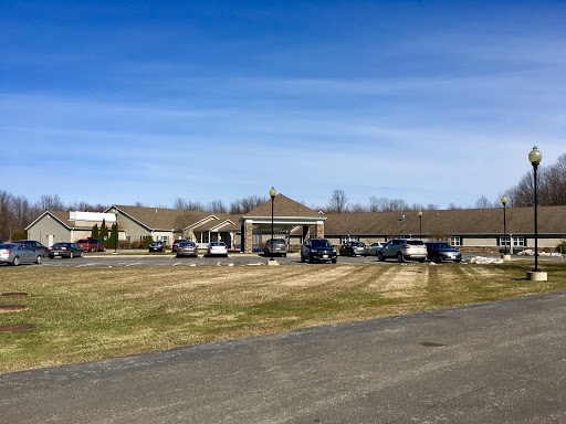 A welcoming facility with a spacious parking area set against a clear blue sky.