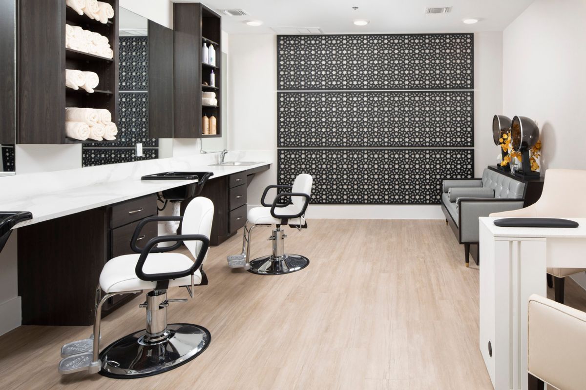 A modern and clean salon interior with styling chairs and mirrors.
