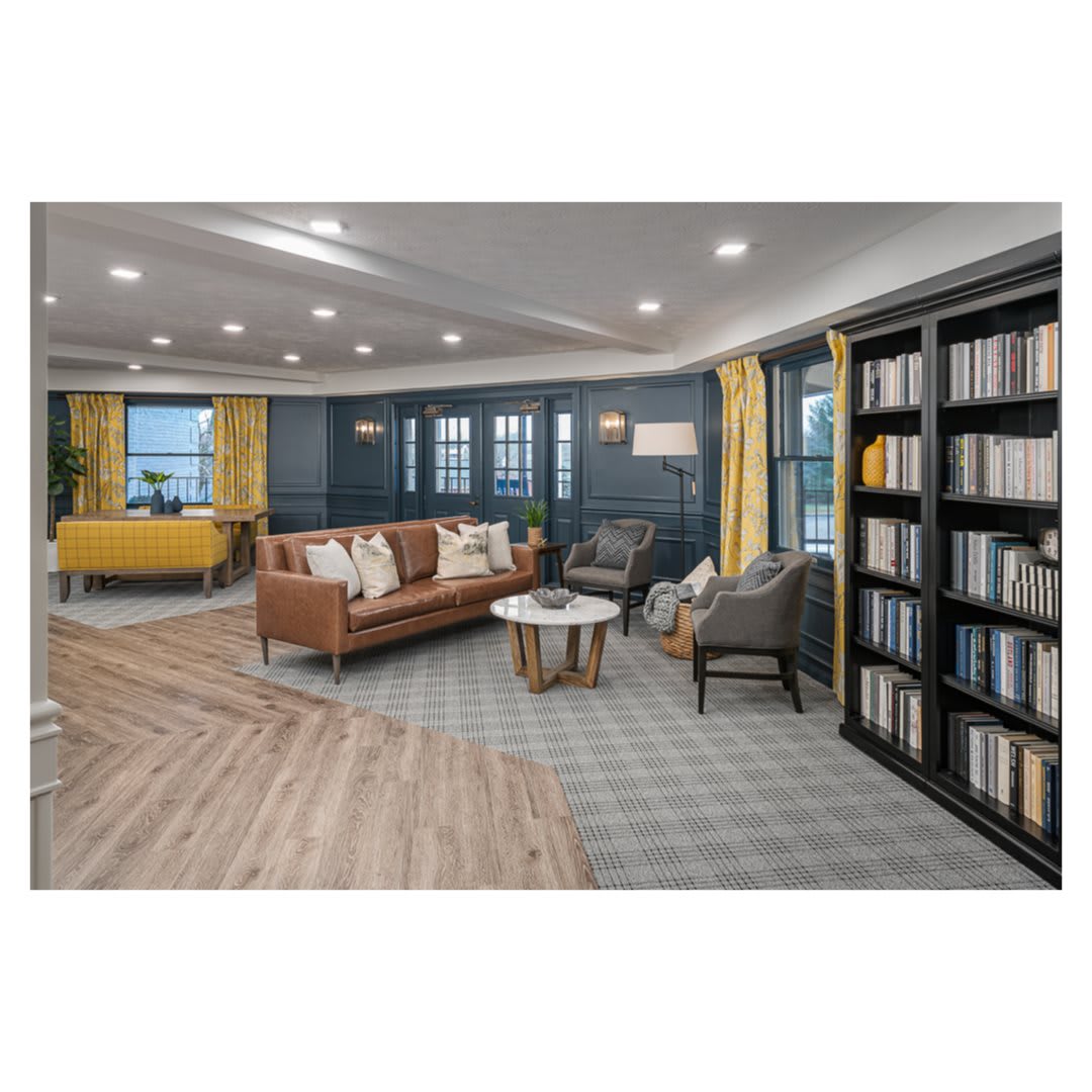 A cozy and modern living room with bookshelves, comfortable seating, and stylish decor.
