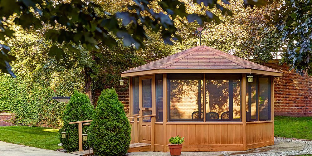 A cozy wooden gazebo nestled among lush greenery in a serene garden setting.