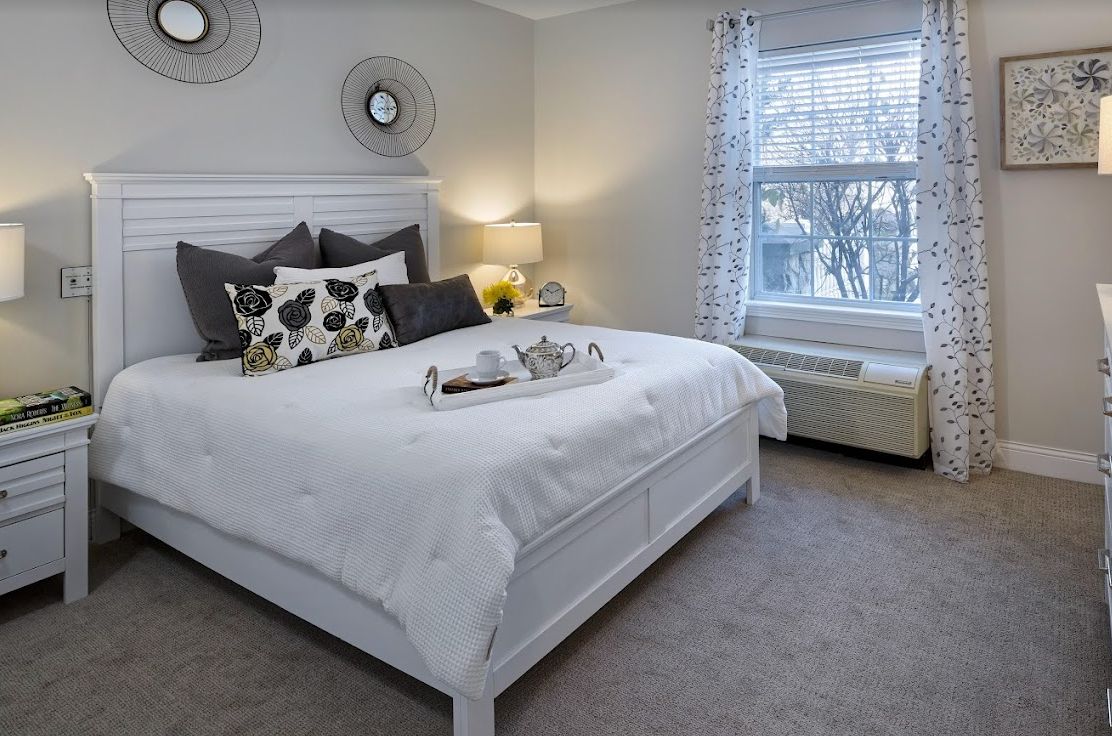 A modern and cozy bedroom with a large bed, soft lighting, and minimalistic decor.