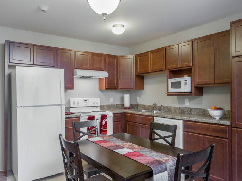 A cozy kitchen with wooden cabinets and a dining area.