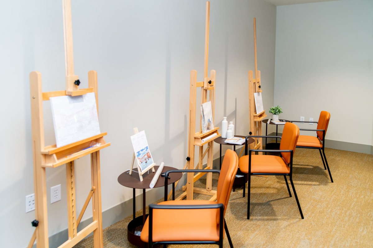 A well-organized art studio featuring easels and comfortable seating, ready for painting sessions.