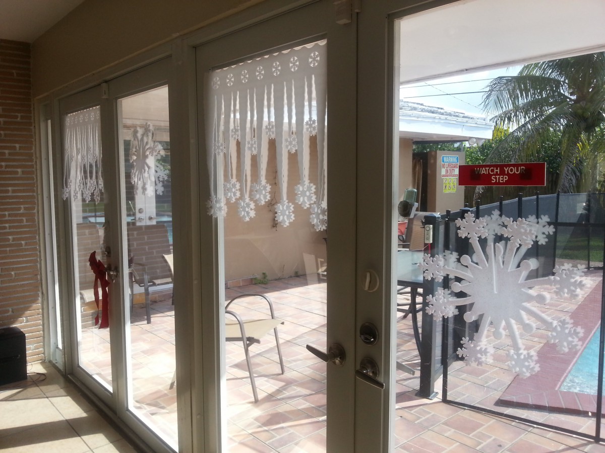 A bright patio view through sliding glass doors adorned with decorative decals.