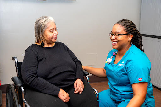 A nurse provides compassionate care and support to an elderly patient during a consultation.