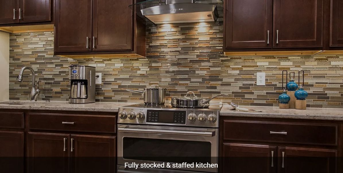 Modern kitchen with a fully stocked stove and stylish backsplash.