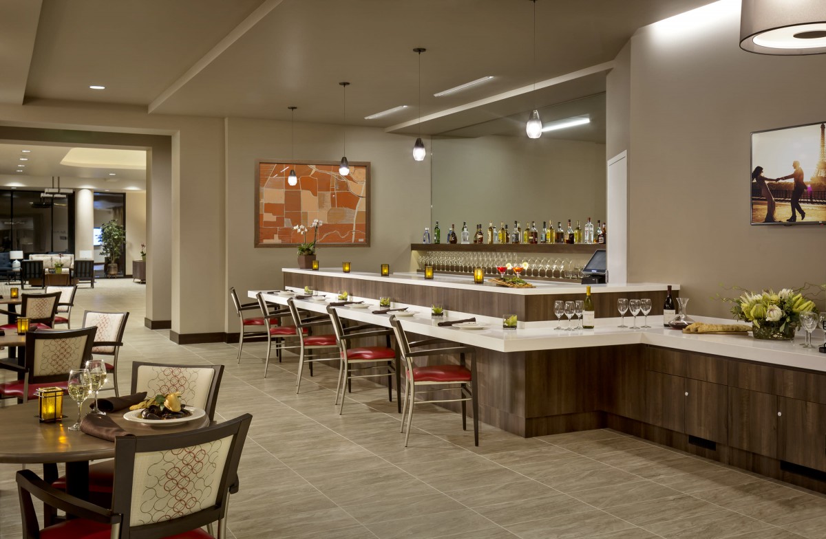 A modern restaurant interior featuring a bar area with seating and contemporary decor.