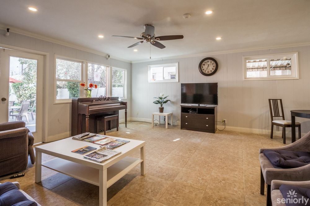 A cozy living room with a piano, TV, and coffee table.
