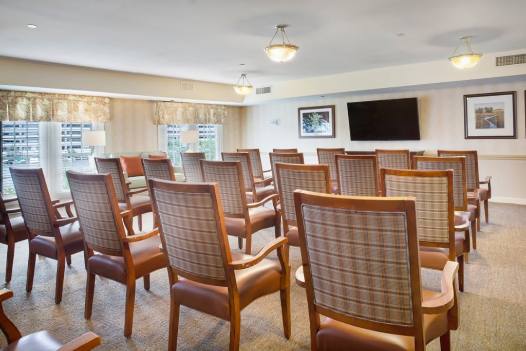 A well-arranged meeting room with chairs facing a television.