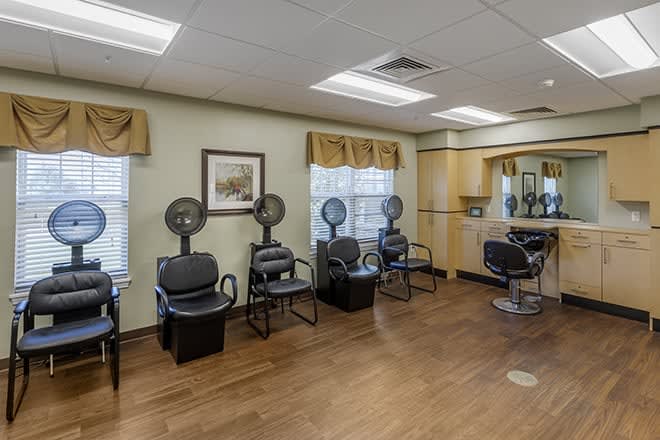 A spacious beauty salon with hair dryers and styling stations.