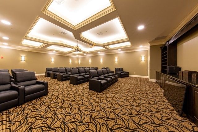A spacious and luxurious home theater with comfortable seating and elegant lighting.