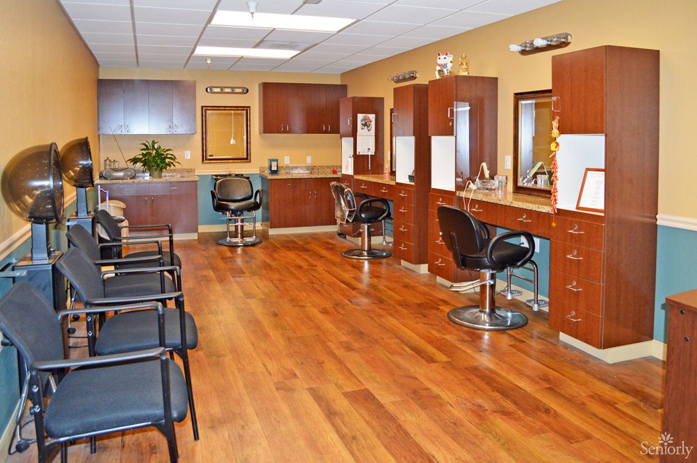 An empty hair salon interior with chairs and mirrors arranged neatly.