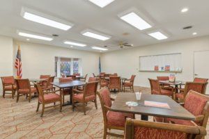 An interior view of an empty dining room with multiple tables and chairs arranged neatly.