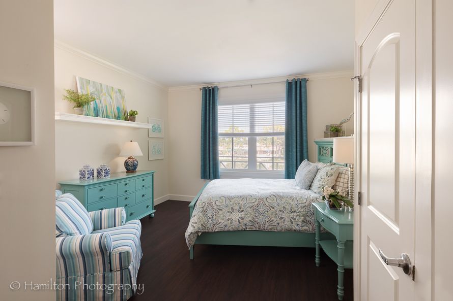 A cozy bedroom featuring turquoise decor and striped furniture.