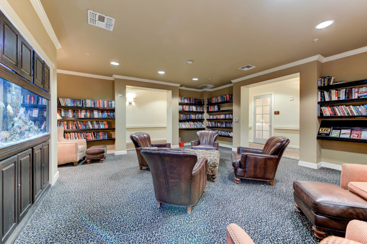 A cozy library interior with armchairs and bookshelves.