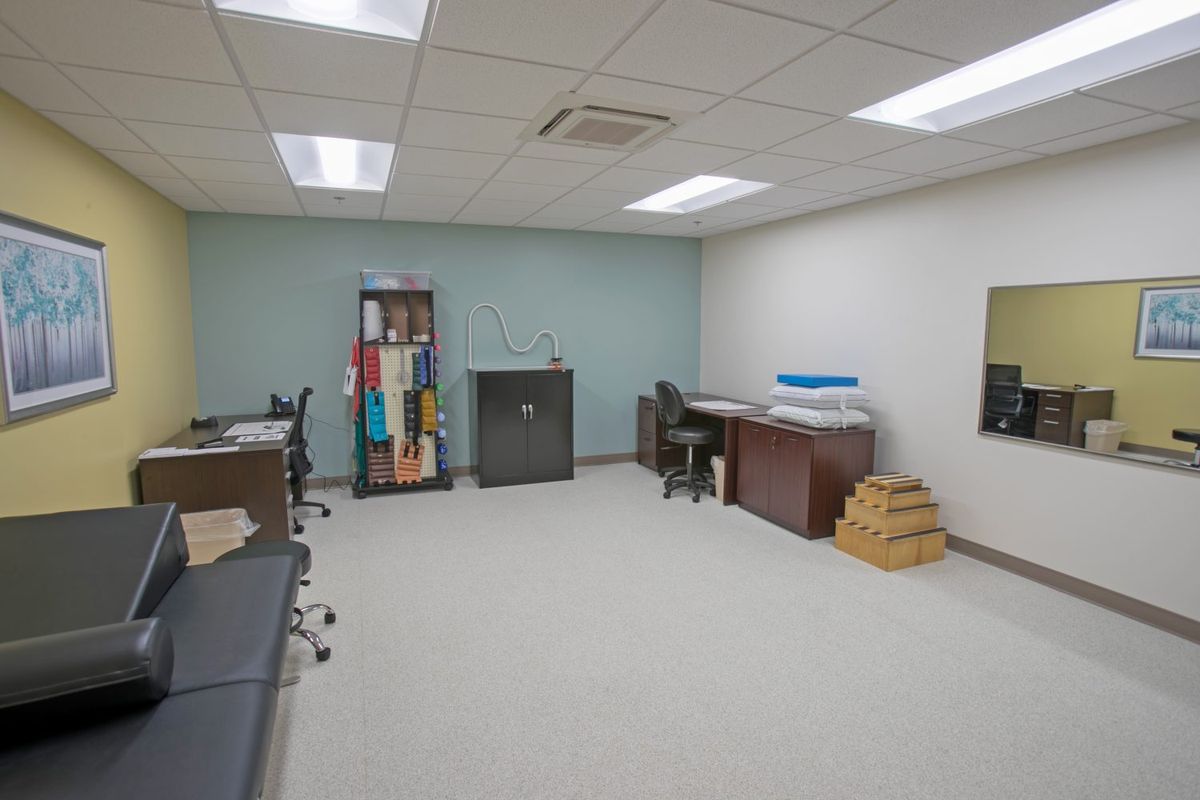 An empty office space with desks, chairs, and storage units.