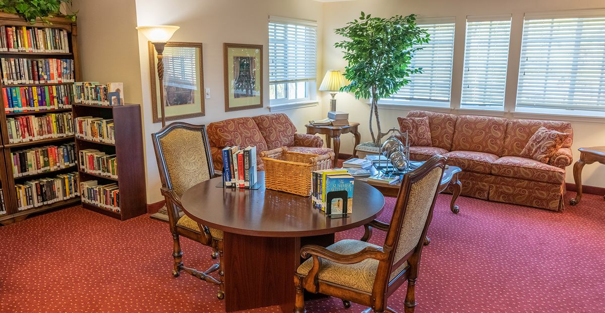 A cozy living room with a round table, chairs, couches, and decorative items.