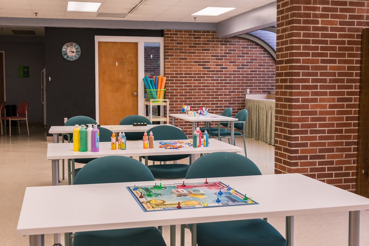A classroom setup with tables and chairs, featuring a board game on one table.