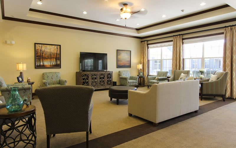 A spacious living room with modern furniture and a large television.
