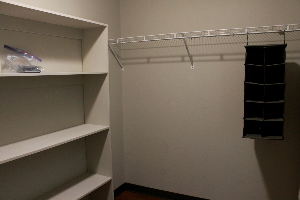 An empty closet with built-in shelves and a wire rack.
