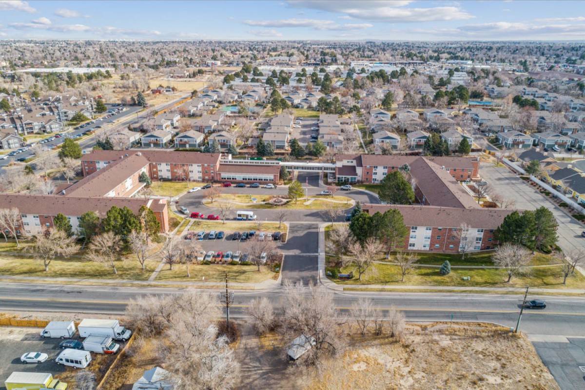 Aerial view of suburban residential area with multiple buildings and surrounding roads.