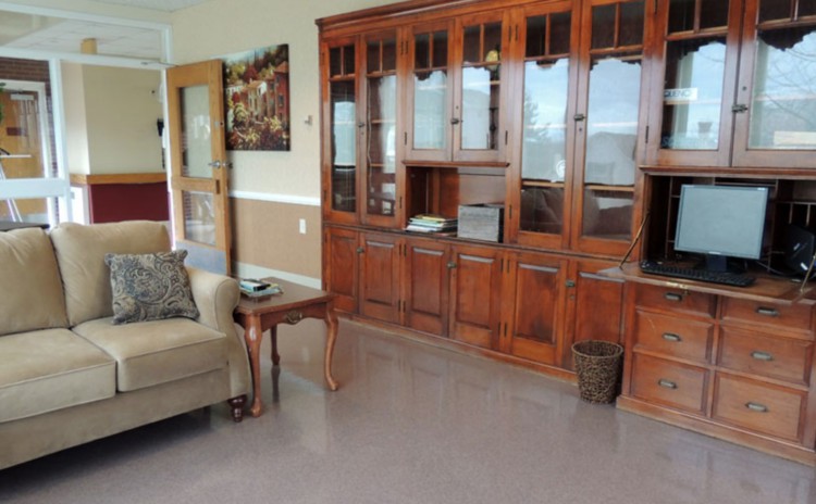 A cozy living room featuring a comfortable sofa and a large wooden cabinet with shelves.