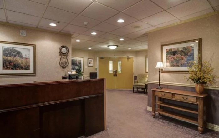 A reception area with a desk, seating, and artwork on the walls.
