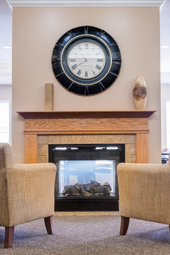 A cozy living room setting featuring a modern fireplace and a stylish wall clock.