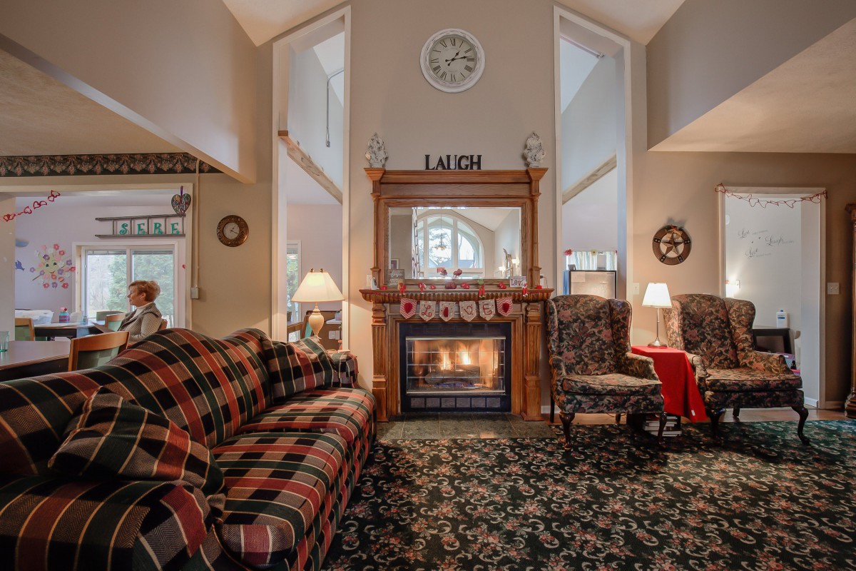 A cozy living room featuring a warm fireplace, traditional decor, and comfortable seating.