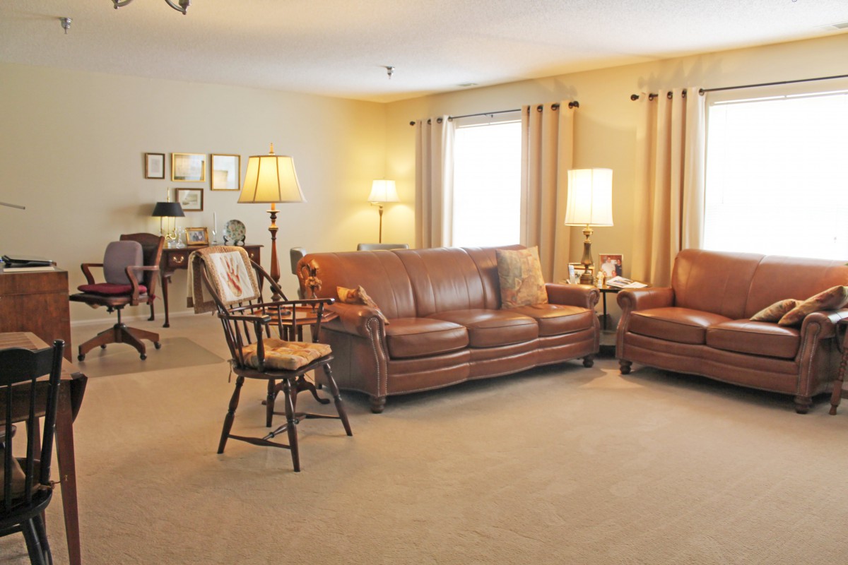 A cozy living room featuring leather sofas and warm lighting.