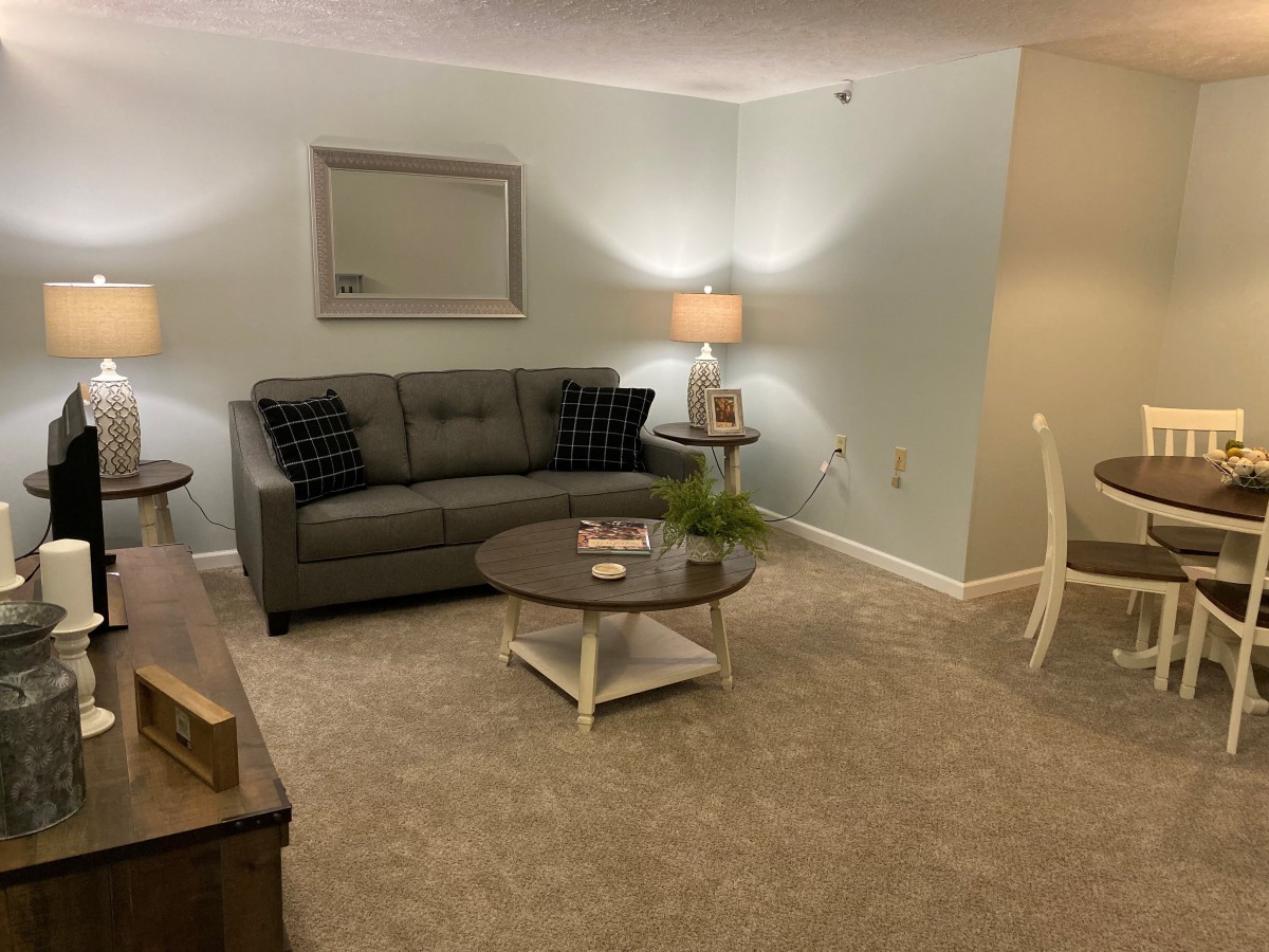 A cozy living room with a sofa, coffee table, and lamp creating an inviting atmosphere.