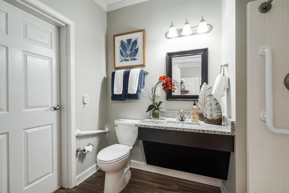 A modern bathroom with contemporary decor, featuring a sink, mirror, and neatly arranged towels.