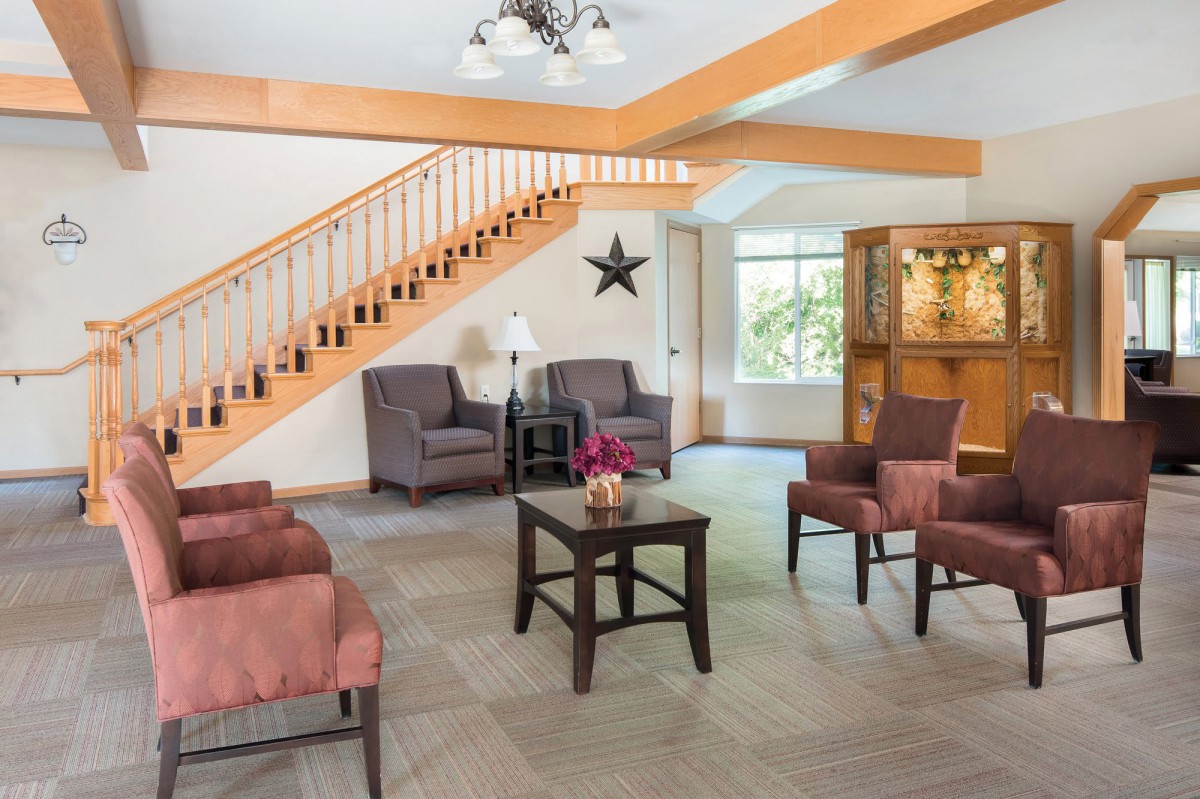 A hotel lobby featuring comfortable seating and a staircase.